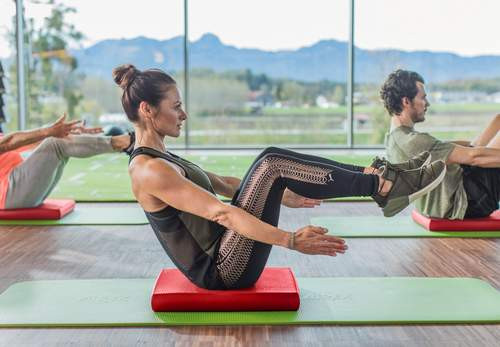 jeune femme assise sur un balance pad pour un exercice de kinésithérapie 