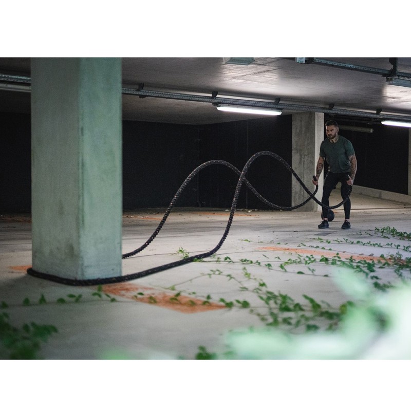un homme qui utilise une corde d'oscillation lors d'une séance de crosstraining