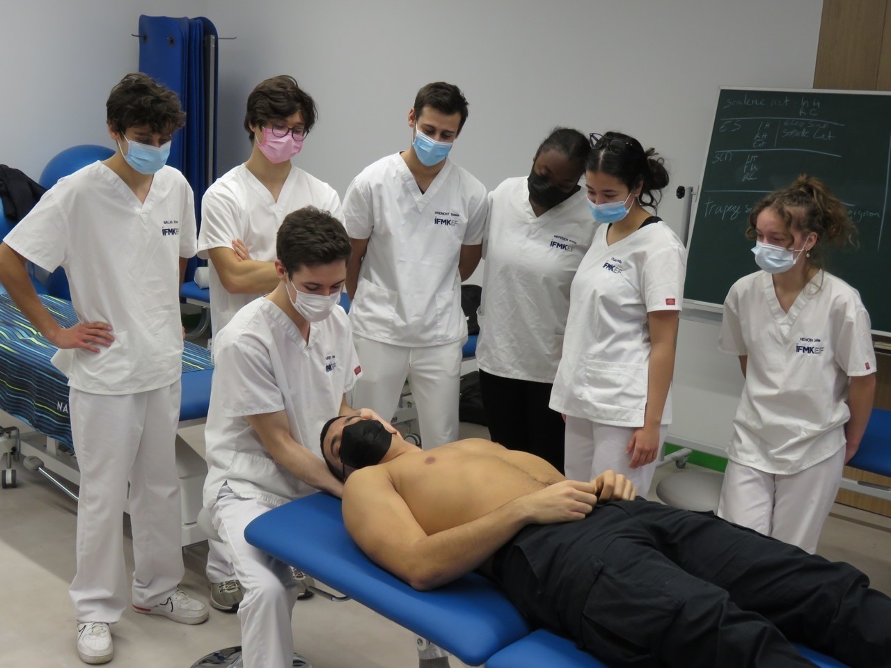 Jeunes étudiants en école de kiné entrain de pratiquer un soin sur un jeune homme