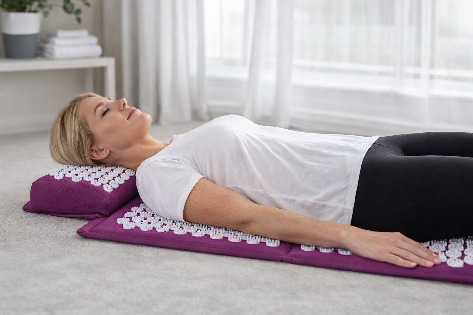 kinésithérapeute allongée sur un tapis d’acupression pour relaxation et soulagement des tensions dorsales