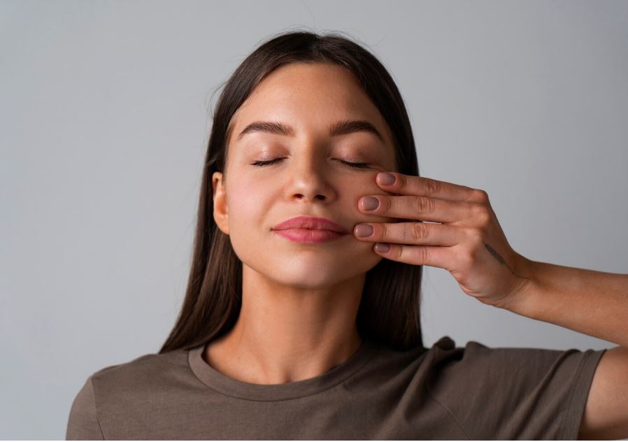 une jeune femme entrain de faire du yoga du visage