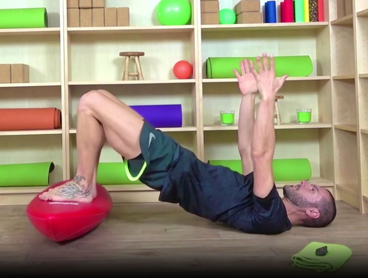 Une homme faisant un exercice au sol sur le dos sur la Toyboard 