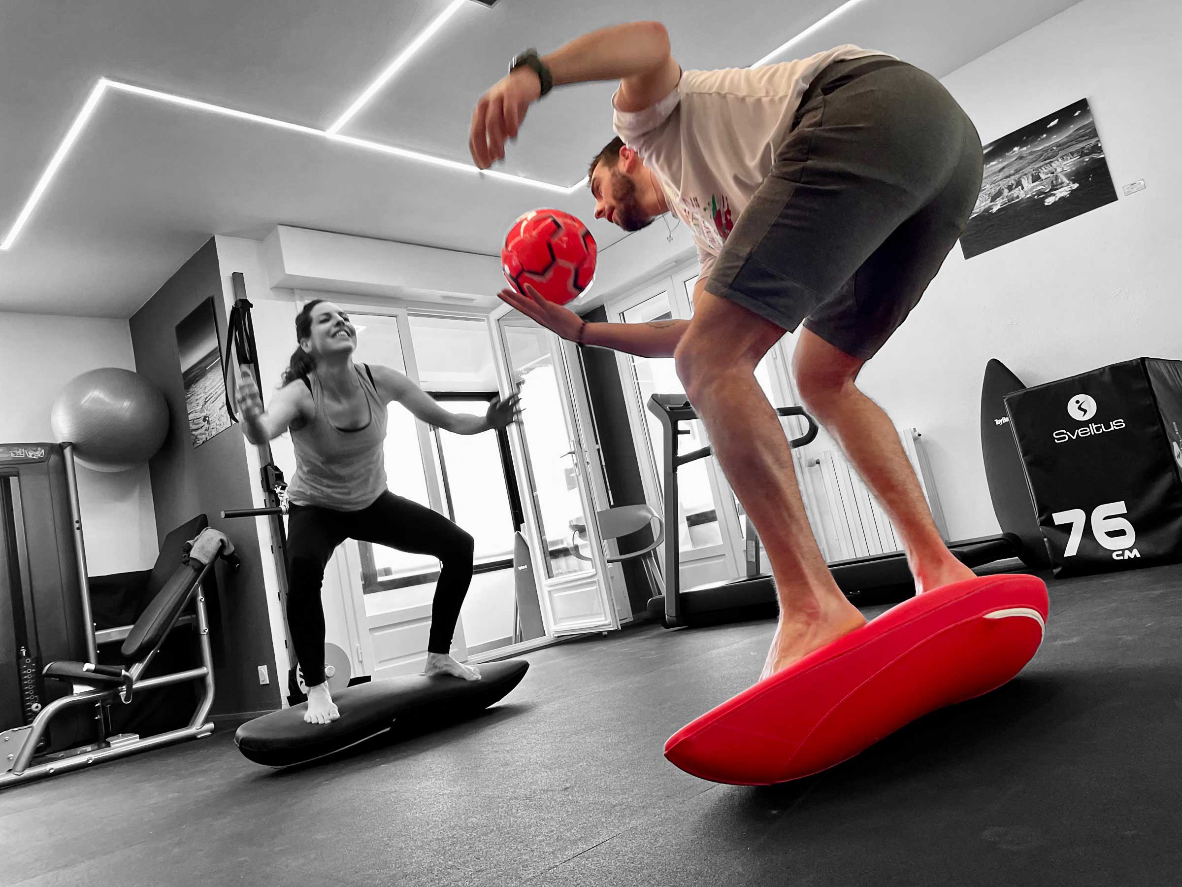 Un sportif avec sa kiné utilisant la Toyboard à l'aide d'un ballon de foot