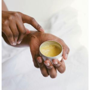 main qui applique du baume du tigre sur un poignet 