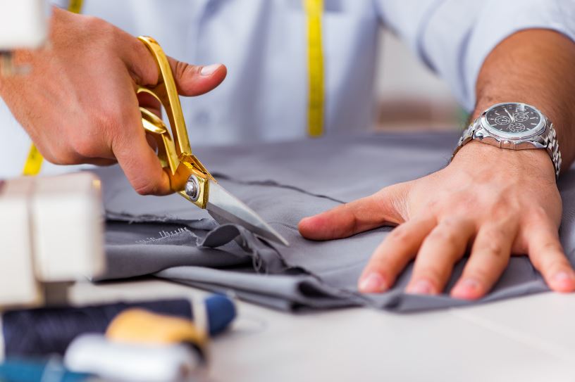 couturier coupant du simili cuir pour la fabrication d’un coussin de positionnement kiné