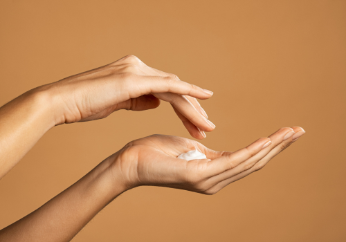 2 mains avec crème de massage dans le creux de l'une pour la kinésithérapie