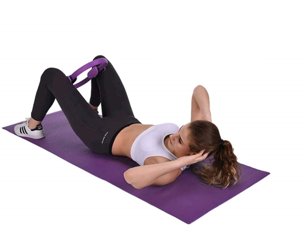 Exercice de Pilates allongé sur le dos avec anneau entre les genoux, pour renforcer le périnée et les adducteurs