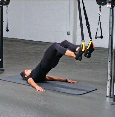 Une femme réalisant un exercice d' extension des bras avec des sangles TRX en kinésithérapie