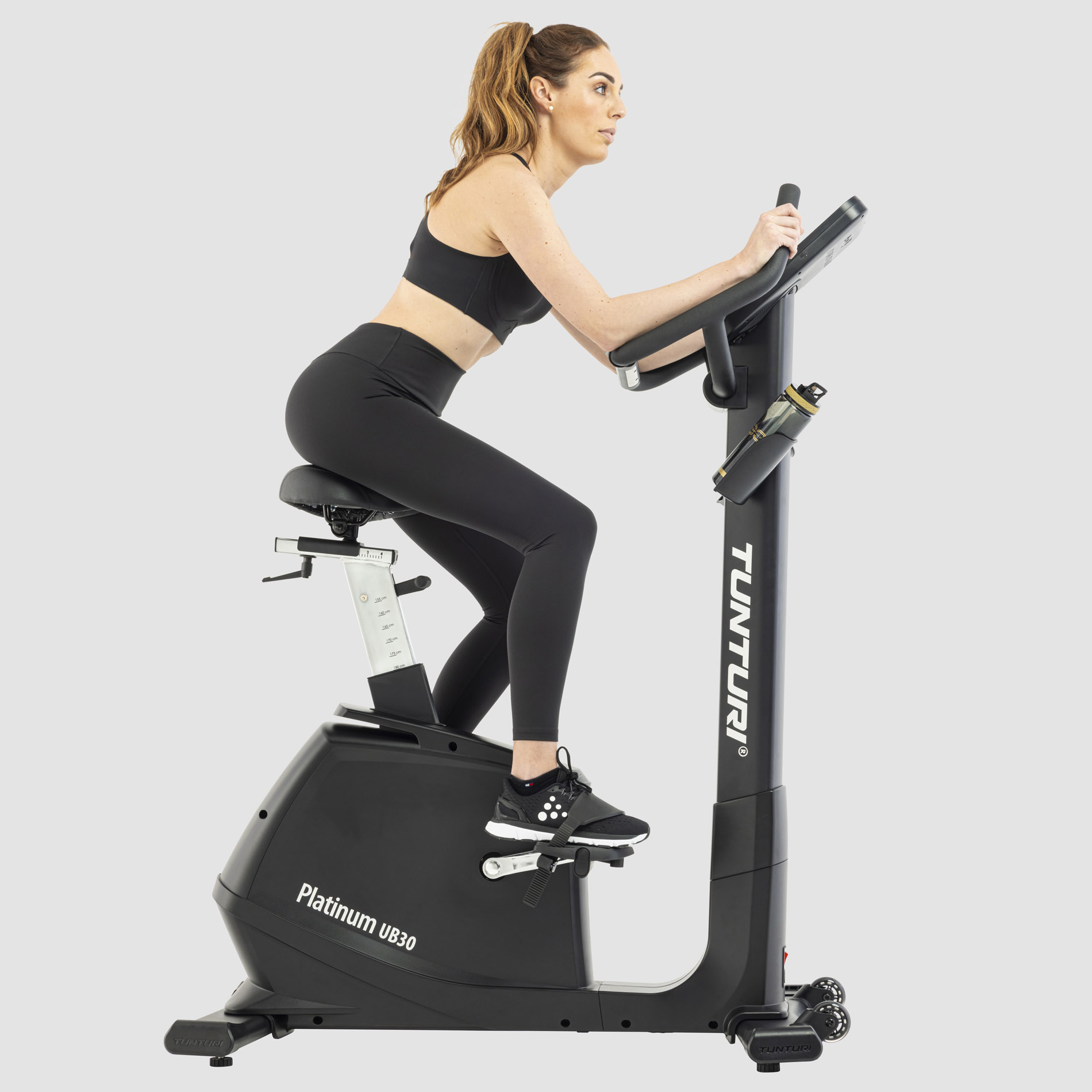 jeune femme en exercice sur un velo droit tunturi platinum