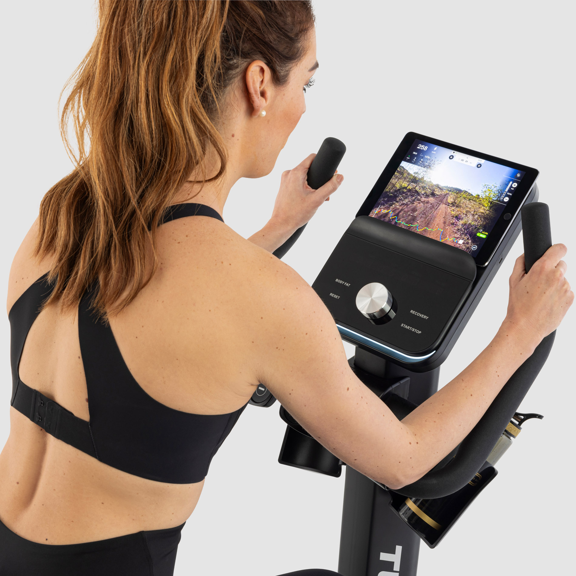 jeune femme en exercice sur un velo droit tunturi platinum