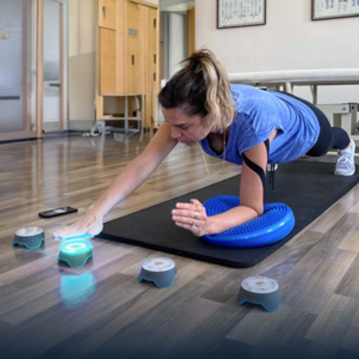 Une femme fesant un exercice de proprioception avec les blazepods en kinésithérapie